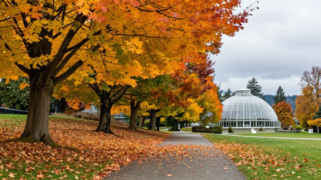 Tree-lined pathway in Queen Elizabeth Park covered in yellow autumn leaves